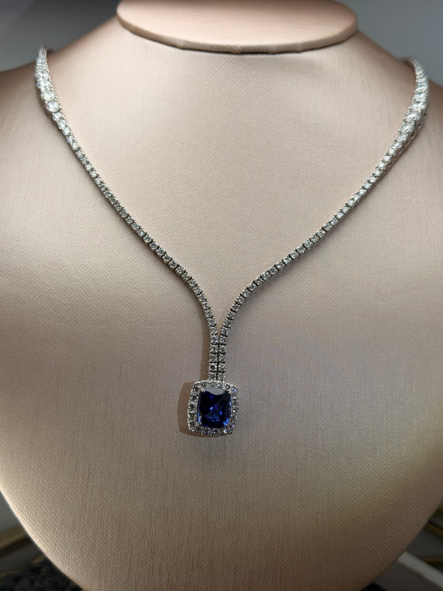 Sapphire and diamond drop necklace on a bust display