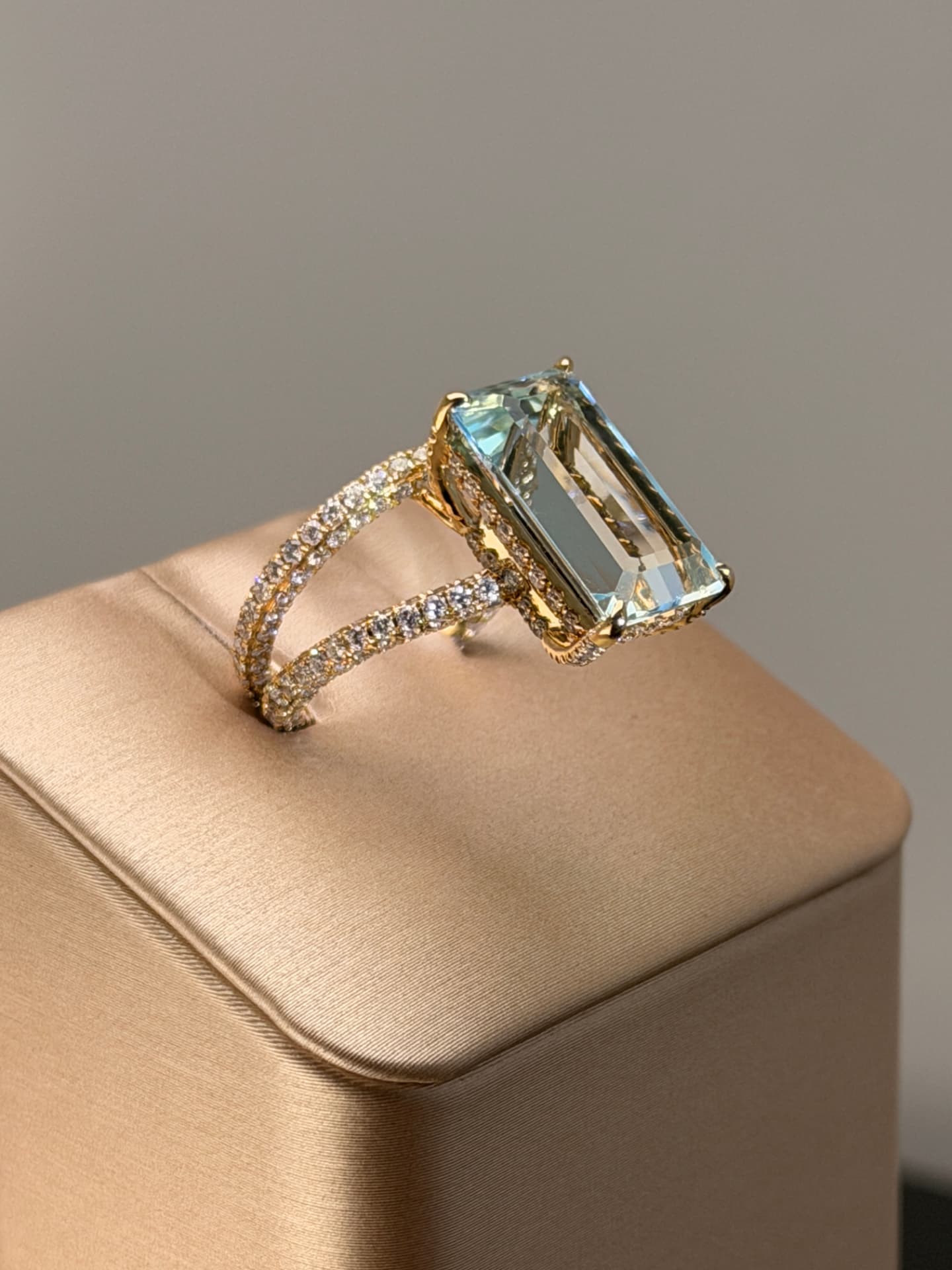 Emerald-cut aquamarine ring with pavé diamond band